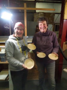 Slightly surprised, yet pleased, students with two bowls.